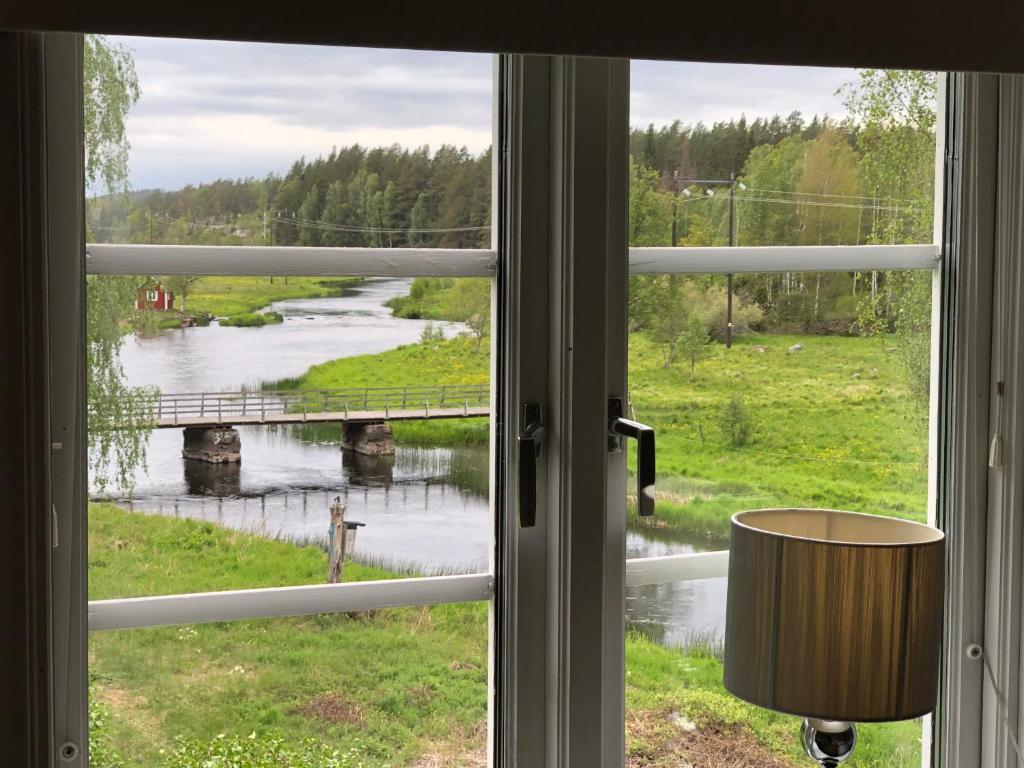 a view of a river from a window at Cosy river house in Kvillsfors