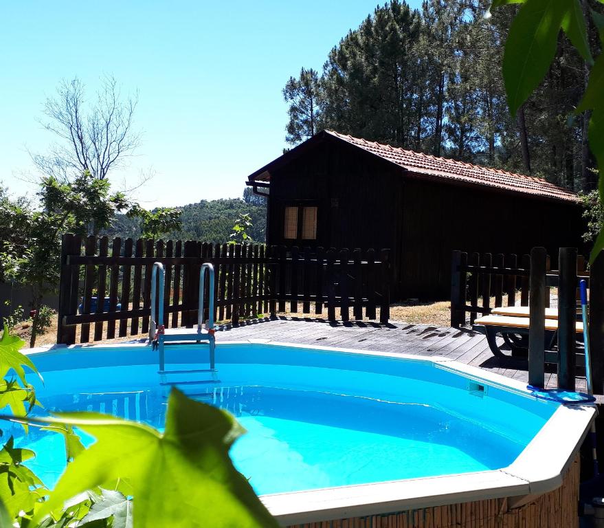 a swimming pool with a house in the background at Casinha do Cedro in Baião