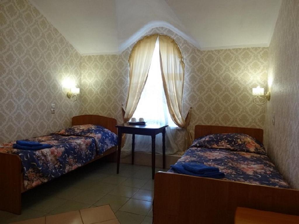 - une chambre avec 2 lits et une fenêtre dans l'établissement Hotel Lotos, à Irkoutsk