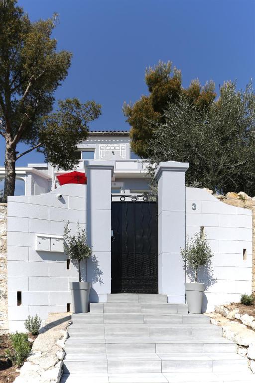 a white house with a black door and stairs at SunRise Cassis in Cassis