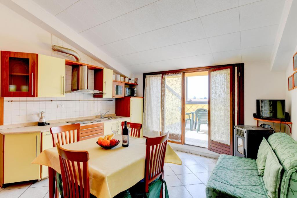 eine Küche und ein Esszimmer mit einem Tisch und Stühlen in der Unterkunft Sarno Apartments Caravaggio in Sirmione