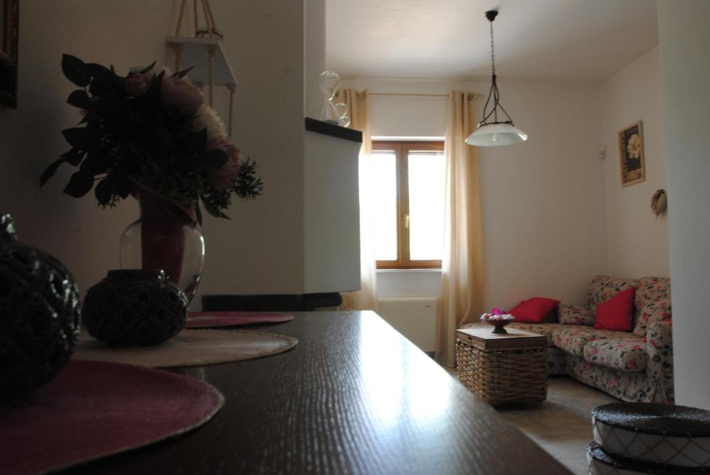 een woonkamer met een vaas met bloemen op een tafel bij A Casa di Kri in Selva di Fasano