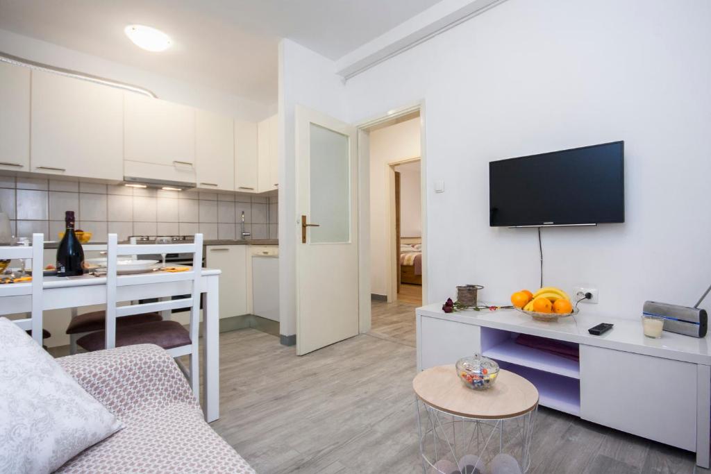 a living room with a couch and a tv on a wall at Apartment Marsela in Šibenik