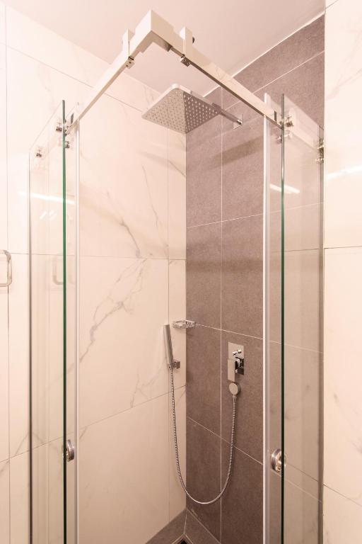 a shower with a glass door in a bathroom at Dependences - San Simon Resort in Izola