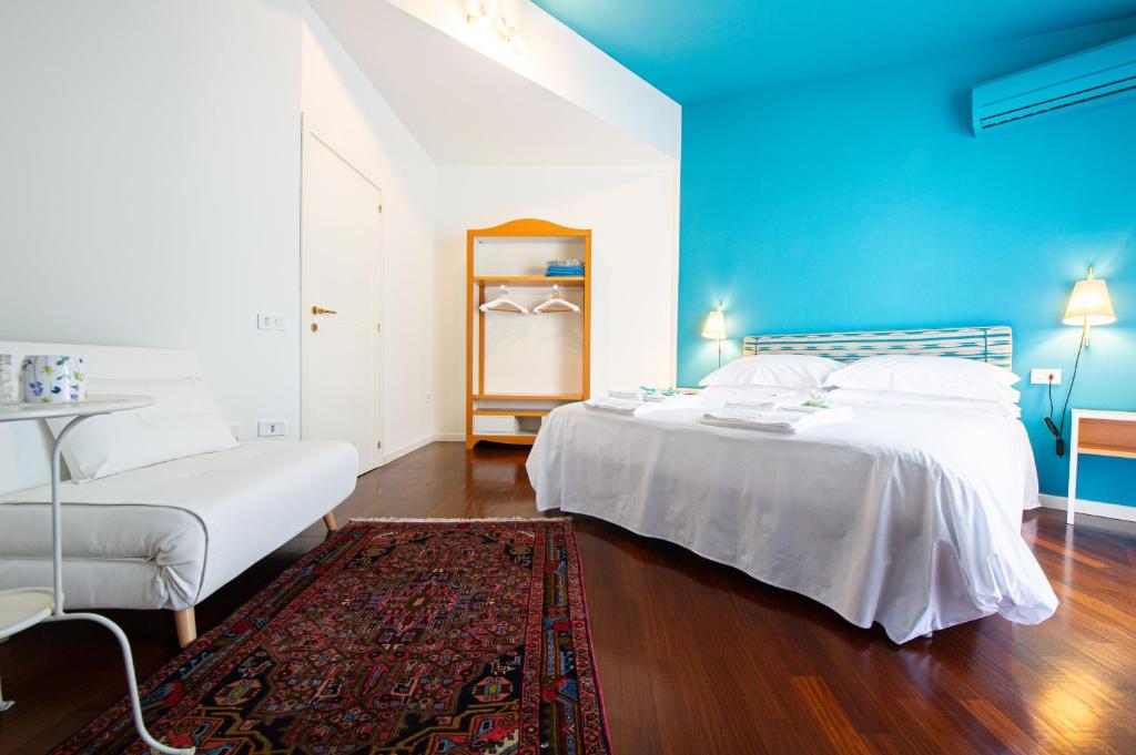 una camera con due letti e una parete blu di L'Angolo di Lore B&B a Fano