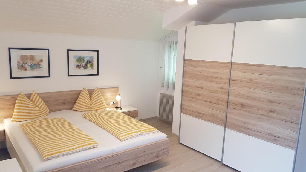 ein Schlafzimmer mit einem Bett mit gelben und weißen Kissen in der Unterkunft Ferienappartements Eschenleit in St. Pankraz