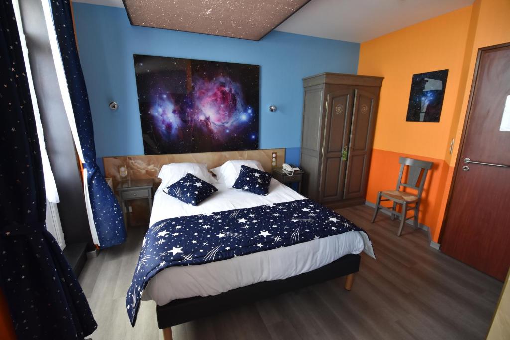 a bedroom with a bed with a blue wall at Hôtel De Calais in Le Tréport