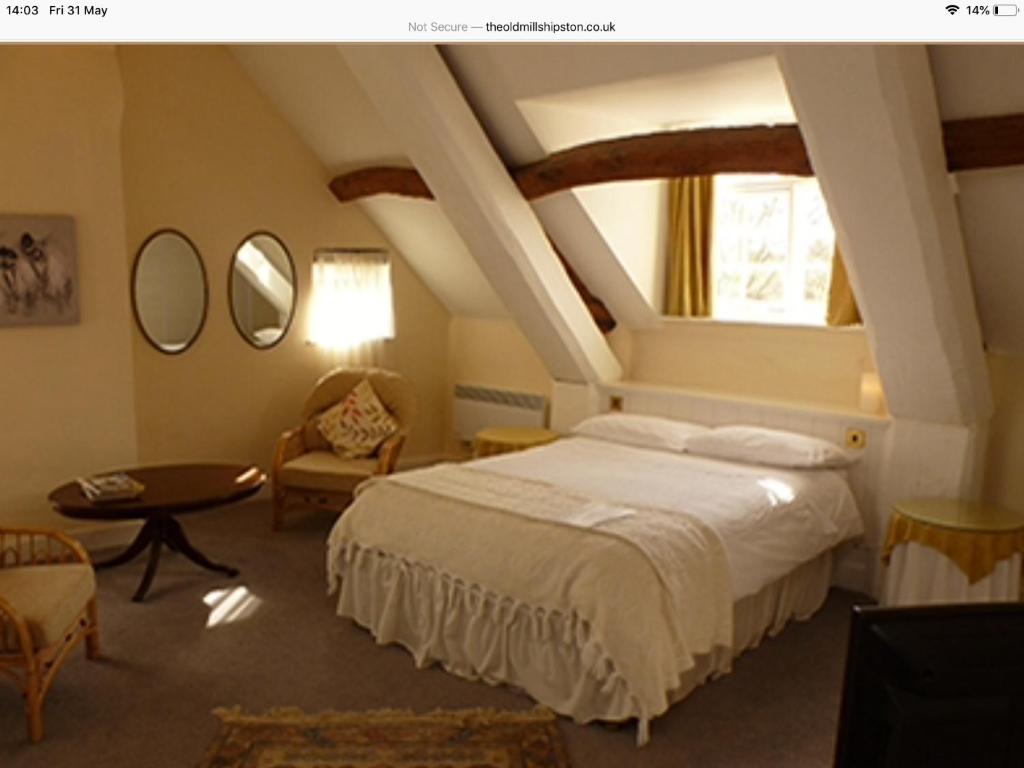 um quarto com uma cama branca e uma janela em The Old Mill em Shipston on Stour