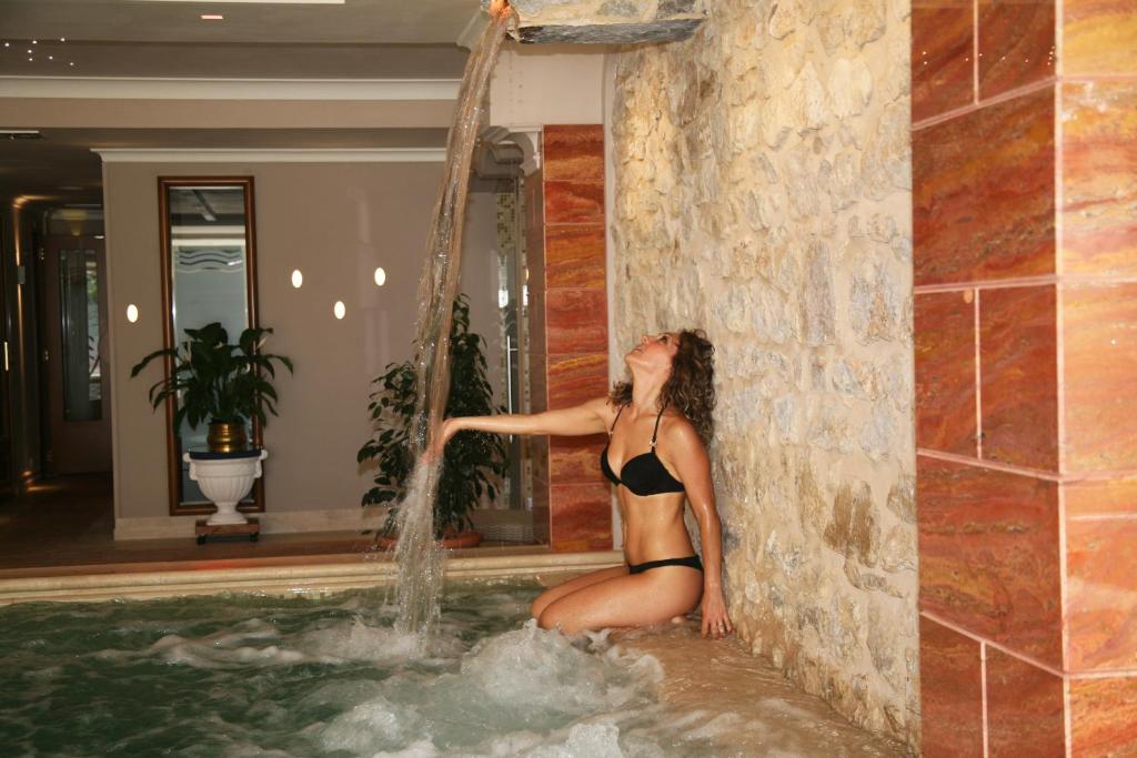 una mujer en traje de baño sentada en una piscina en Hotel Argentina & SPA, en Fiuggi