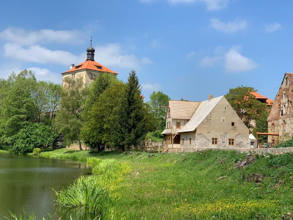 an old house and a barn next to a river at Malešov Camp in Malešov
