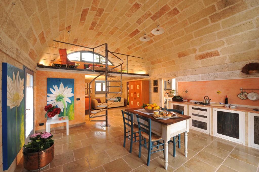 cocina con mesa y escalera de caracol en una habitación en Case Fra Gli Ulivi, en Spongano