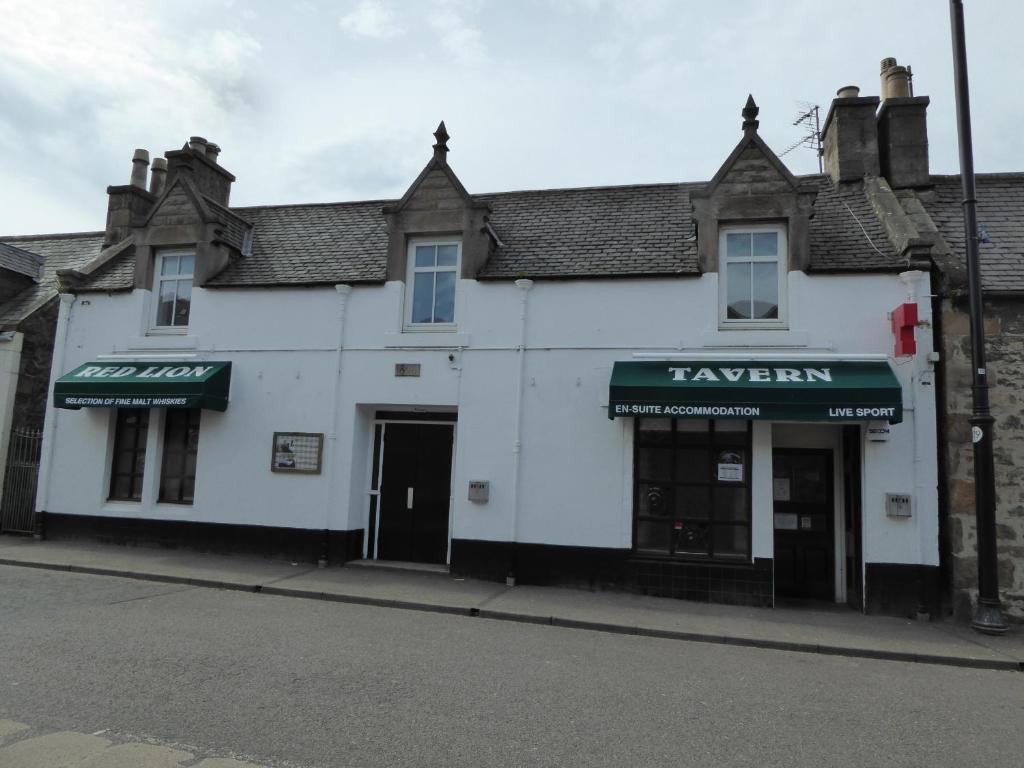 a white building with a sign for a tavern at The Red Lion Tavern in Fochabers