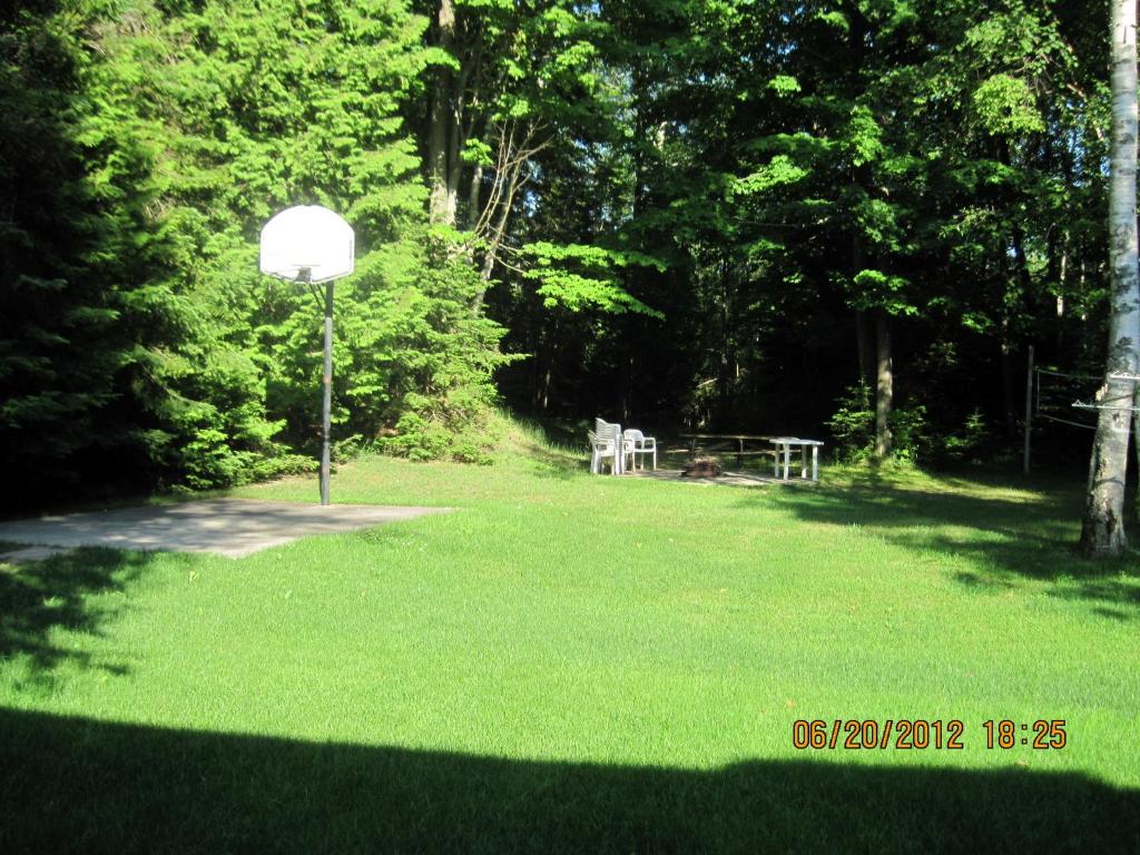 a park with a basketball hoop in the grass at Sunny Birch Cottages in Sauble Beach