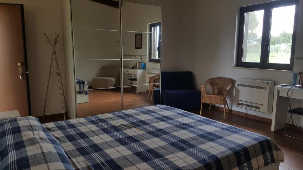 um quarto com uma cama com um cobertor xadrez azul e branco em Palazzo Piccolo em Ascoli Satriano