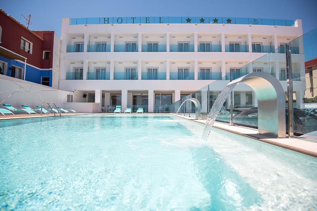 a swimming pool with a fountain in front of a building at Hotel Sol de Jávea in Jávea