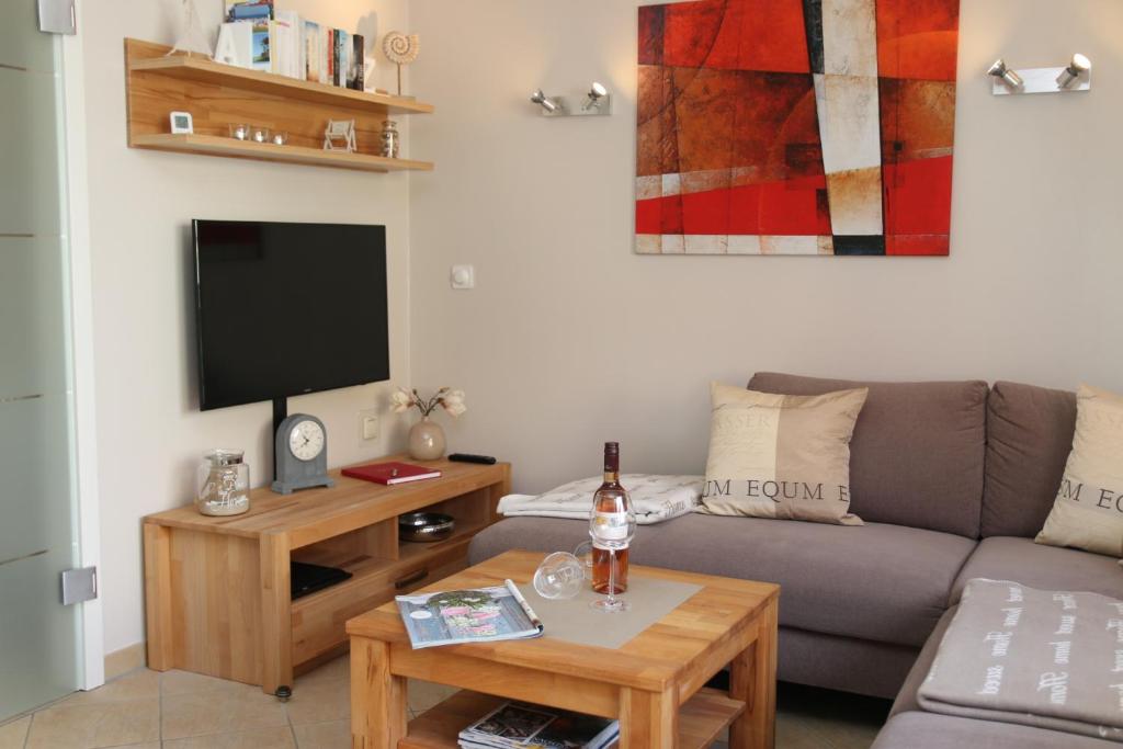 a living room with a couch and a tv at Ferienwohnung Strandaster in Zingst