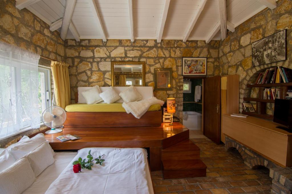 1 dormitorio con 1 cama en una pared de piedra en Corfu Town Mini Villa Private Pool Gardens, en Mantoúkion
