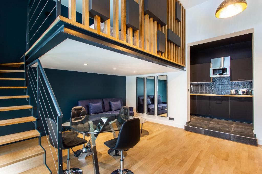 une salle à manger avec une table et des chaises et un escalier dans l'établissement Modern studio for 4 people - Arc de Triomphe, à Paris