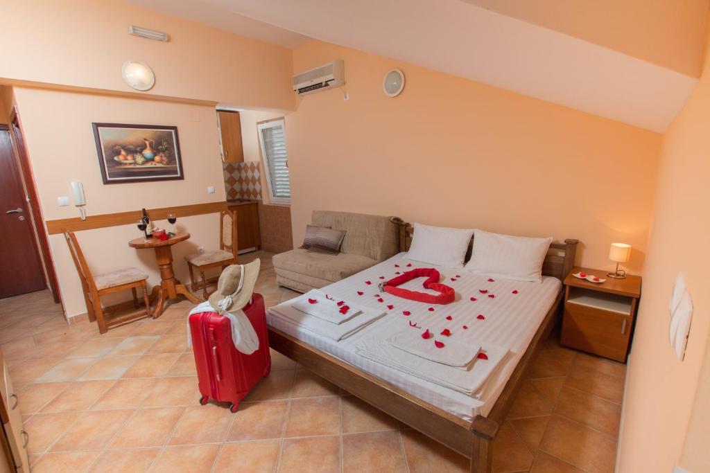 a bedroom with a bed with a red suitcase at Adzic Apartments in Budva