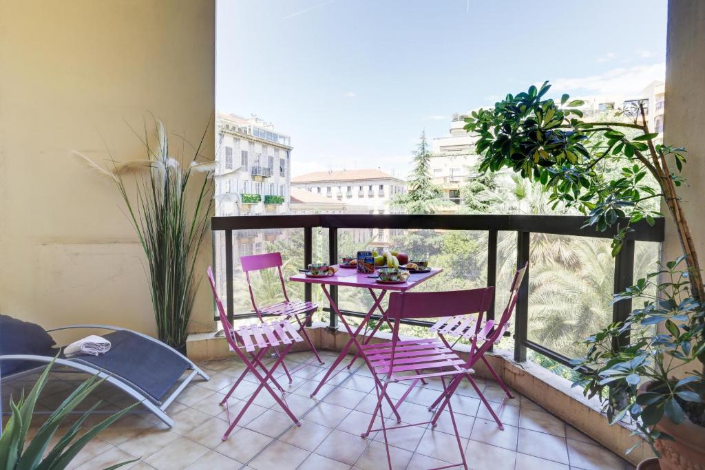 un balcon avec une table et des chaises sur un balcon dans l'établissement GRAND H -F2, FACE VIEUX- NICE, TERRASSE, ASCENSEUR, CLIMATISATION, Terrace - Nice city center, à Nice