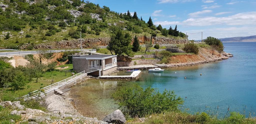 ein Haus am Ufer eines Wasserkörpers in der Unterkunft Kuća za odmor Jelena in Starigrad-Paklenica