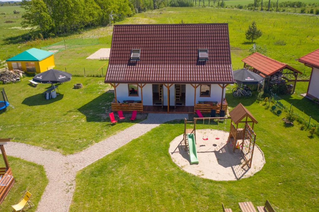 an aerial view of a small house with a playground at Domek Werbena in Ustka