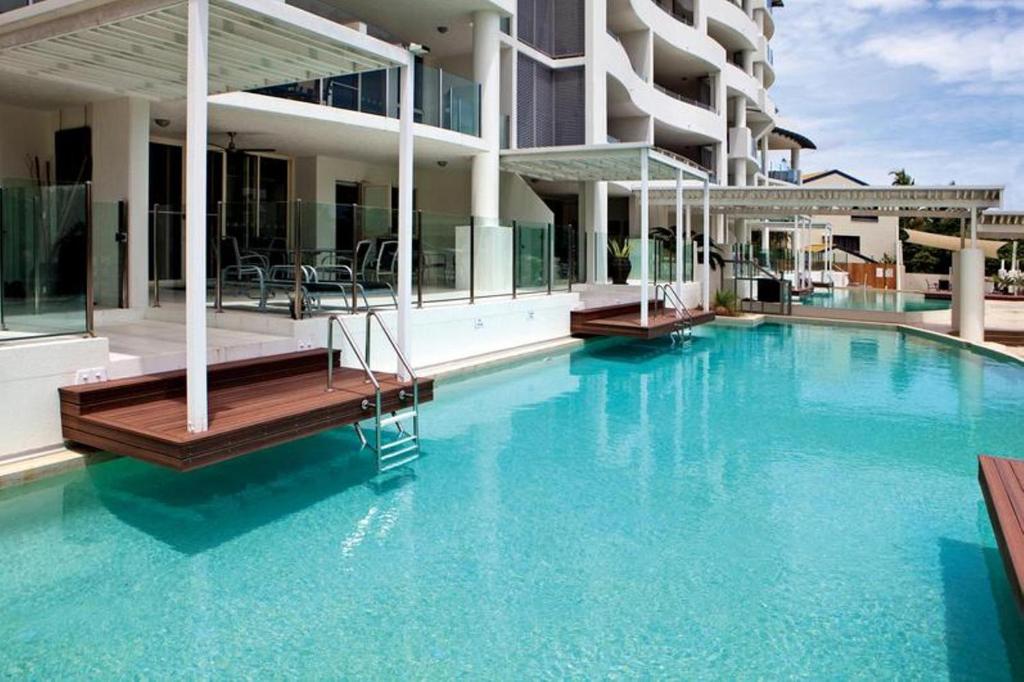 a hotel room with a pool and a pool table at Waters Edge Apartment Cairns in Cairns