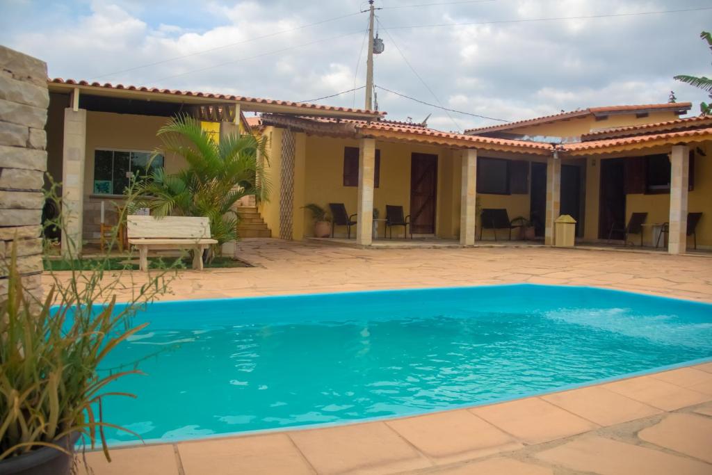 a villa with a swimming pool in front of a house at Pousada e Chales Por do Sol in São Thomé das Letras
