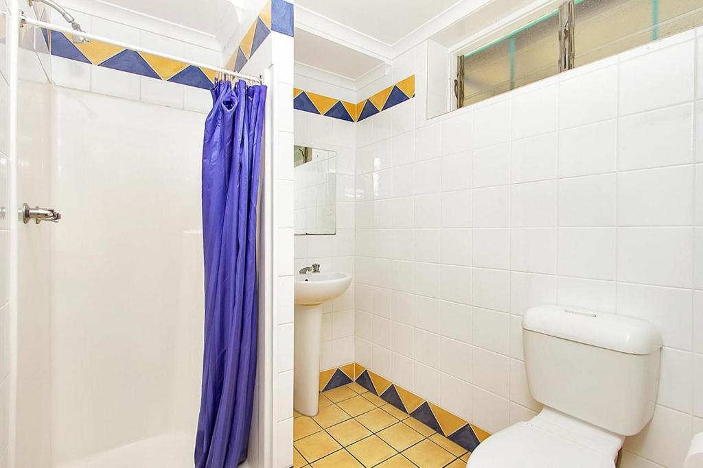 a bathroom with a toilet and a sink at Caravella Backpackers in Cairns