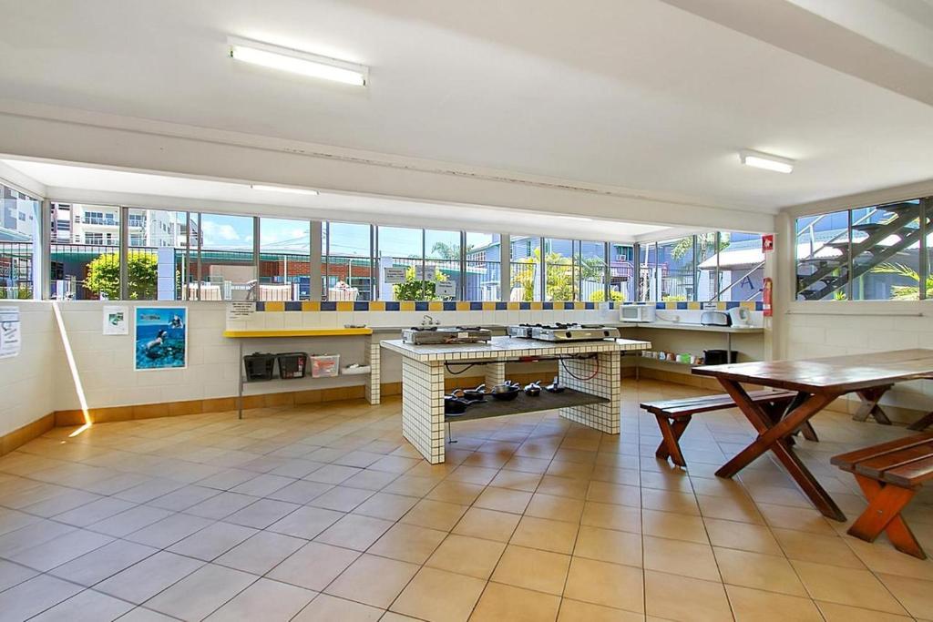 a large room with a table and some windows at Caravella Backpackers in Cairns