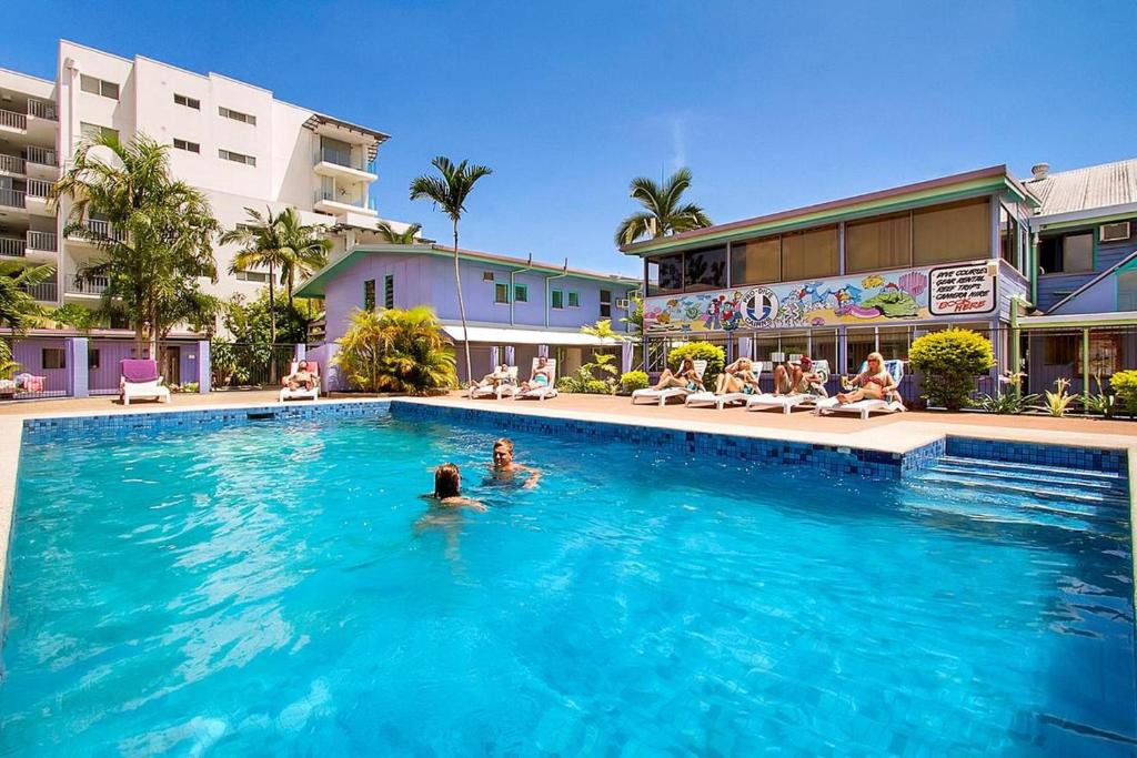 a person in the swimming pool at a hotel at Caravella Backpackers in Cairns