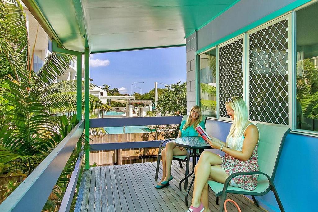 two women sitting on the porch of a house at Caravella Backpackers in Cairns