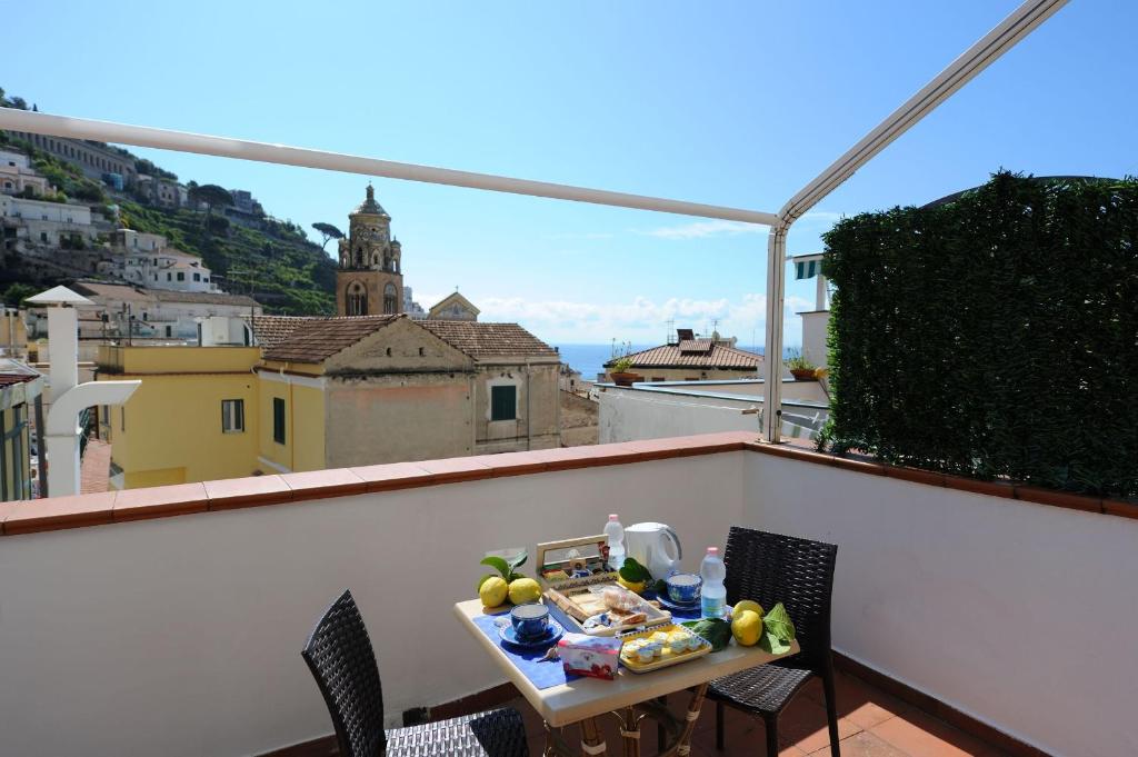 una mesa en un balcón con vistas a la ciudad en Beautiful Lights Guest House, en Amalfi