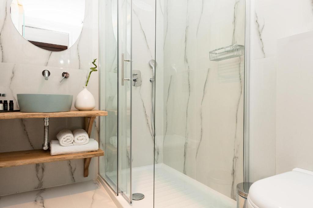 a bathroom with a glass shower stall and a sink at Hotel Villa Natassa in Skala Rachoniou