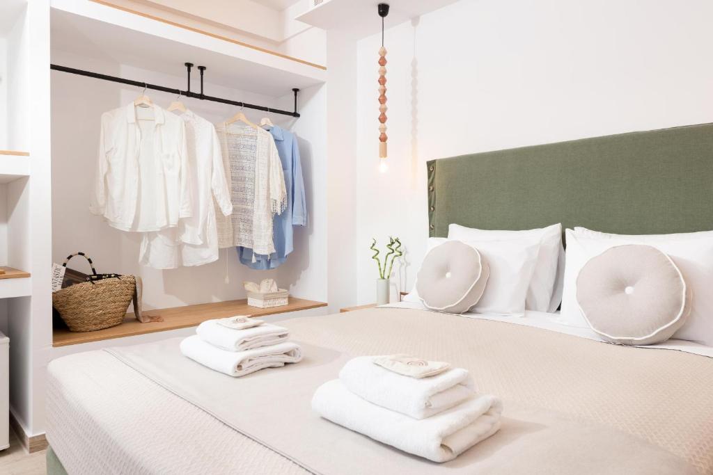 a bedroom with a white bed with towels on it at Hotel Villa Natassa in Skala Rachoniou