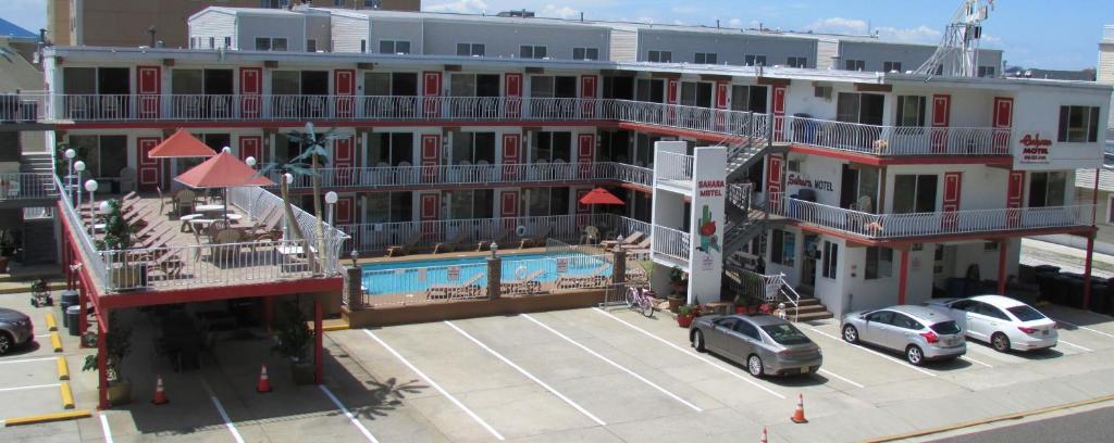 a large building with a pool and cars parked in a parking lot at Sahara Motel in North Wildwood