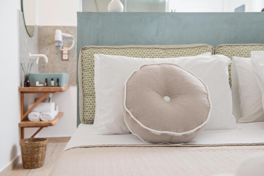 a donut pillow on a bed with white pillows at Hotel Villa Natassa in Skala Rachoniou