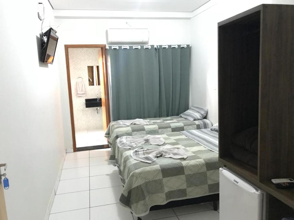 Habitación pequeña con 2 camas y ducha en Hotel Luz, en Fronteira