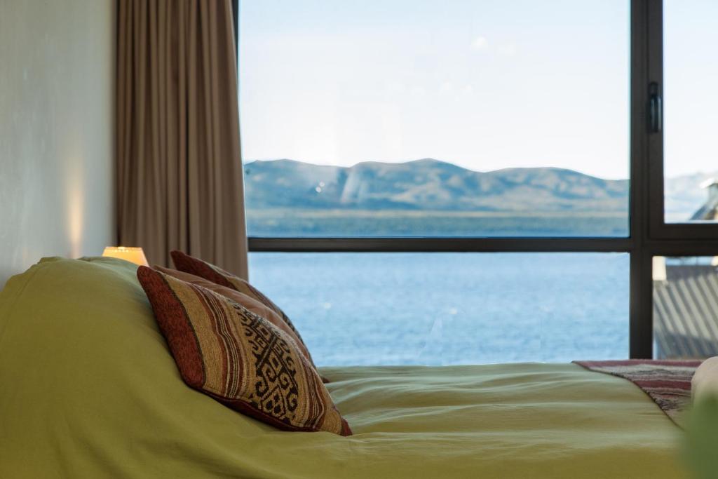 uma cama com duas almofadas em frente a uma janela em Studio Bariloche em San Carlos de Bariloche