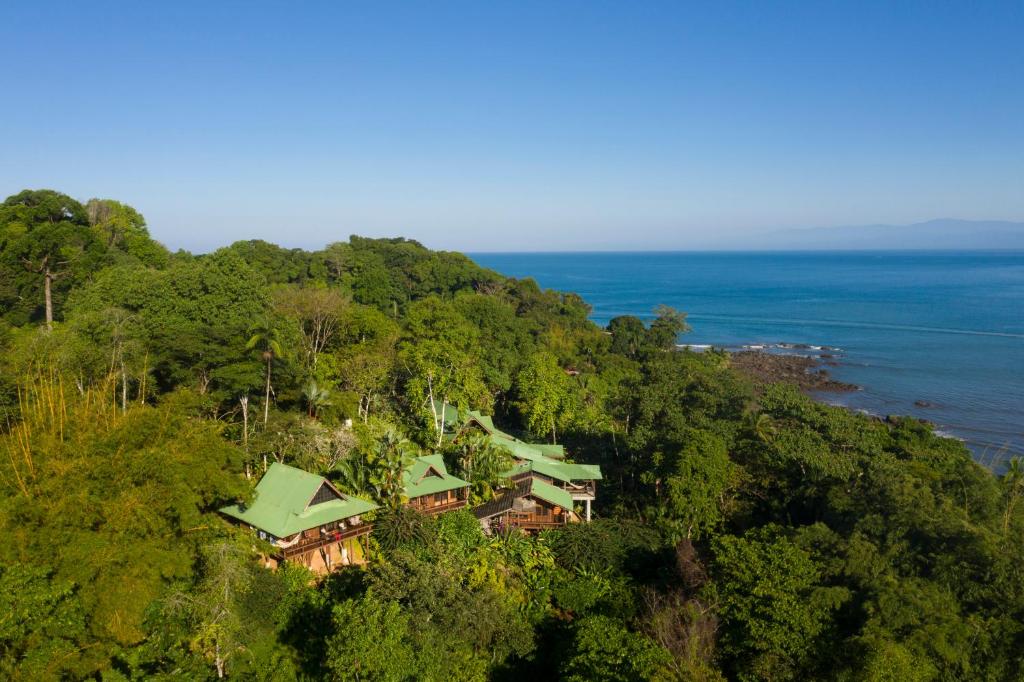 a house on top of a hill next to the ocean at Aguila de Osa Rainforest Lodge in Drake