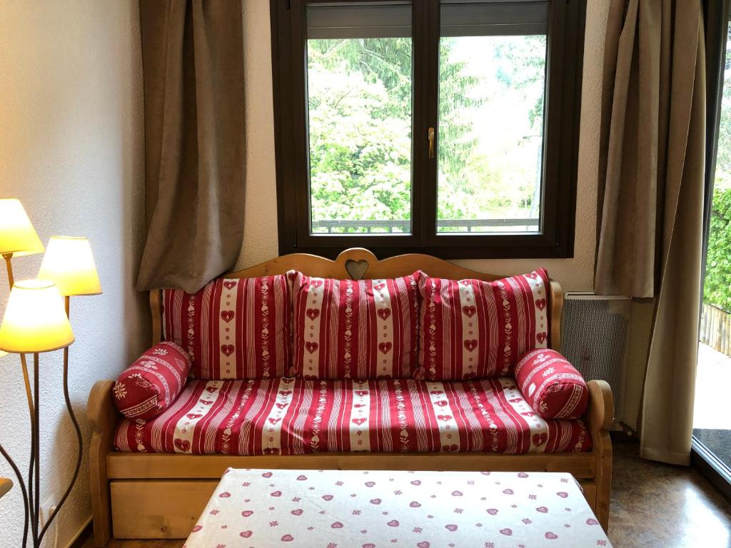 - un canapé rouge dans une chambre avec 2 fenêtres dans l'établissement Mont Blanc View Chamonix Apartment, à Chamonix-Mont-Blanc