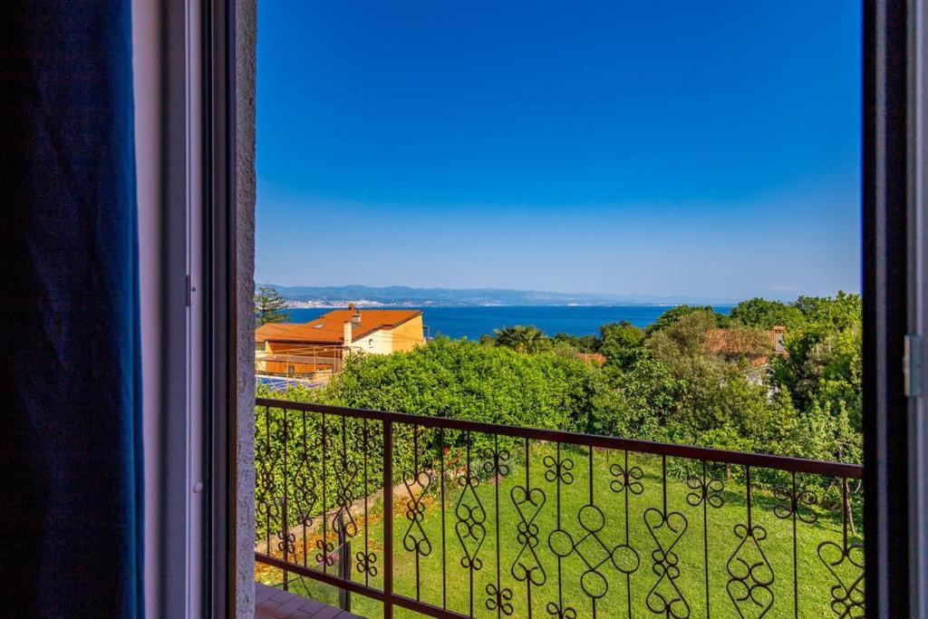 een kamer met een balkon met uitzicht op de oceaan bij Apartman Roza in Ičići