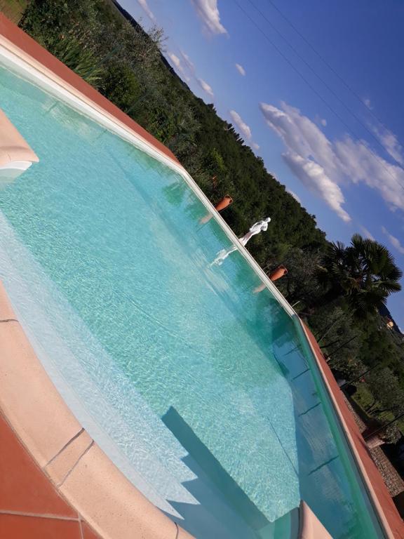 a swimming pool with blue water in a resort at La Vecchia Quercia in Pergine Valdarno