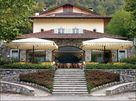 a large house with a staircase in front of it at Residence Antico Crotto in Porlezza