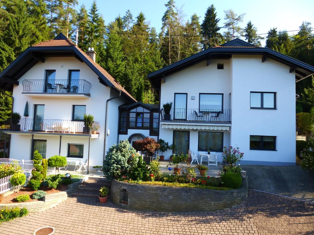 una vista exterior de una casa blanca con patio en Appartements Kronig, en Pörtschach am Wörthersee