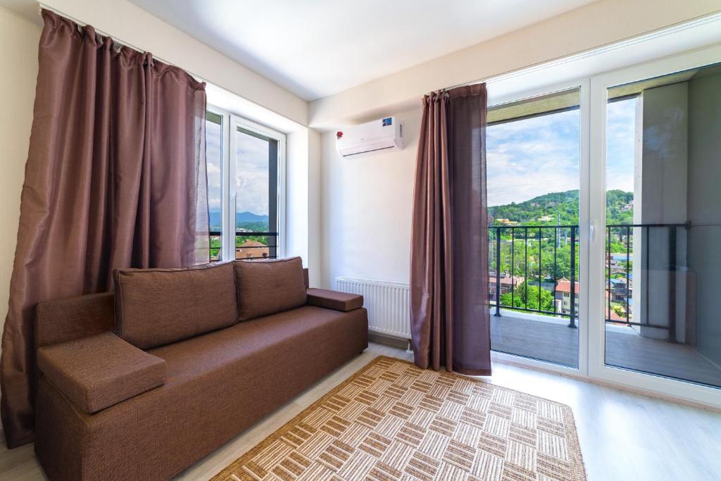 ein Wohnzimmer mit einem Sofa und einem großen Fenster in der Unterkunft Apartment on Staroshosseinaya 5/6 in Sochi