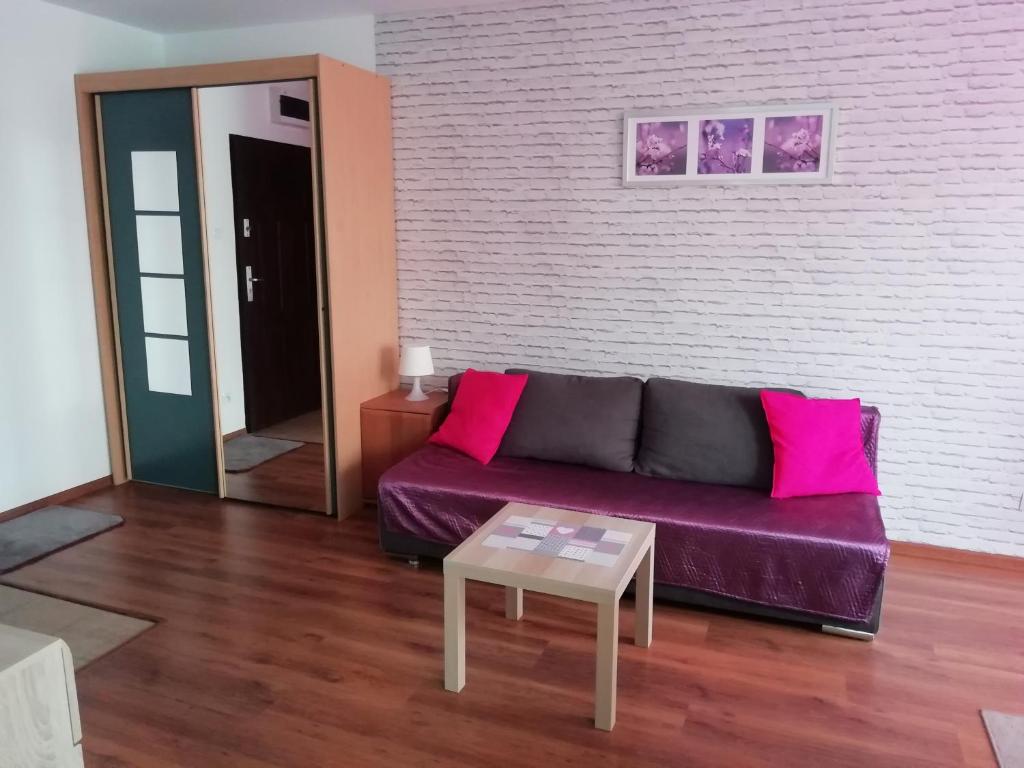 a living room with a purple couch and a table at Apartament u Magdy in Międzyzdroje