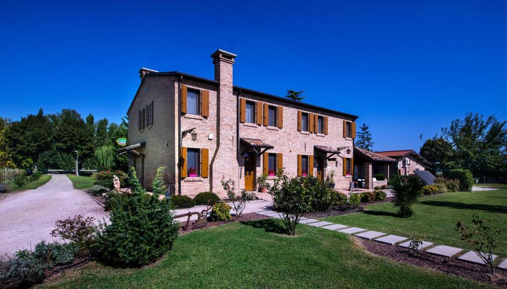 un gran edificio de ladrillo con una chimenea encima en Il Dosso Agriturismo, en Codigoro