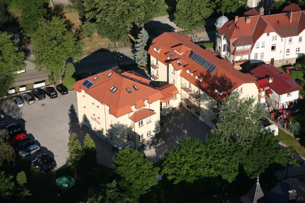 widok na duży dom z pomarańczowymi dachami w obiekcie Villa Tilia w Polanicy Zdroju