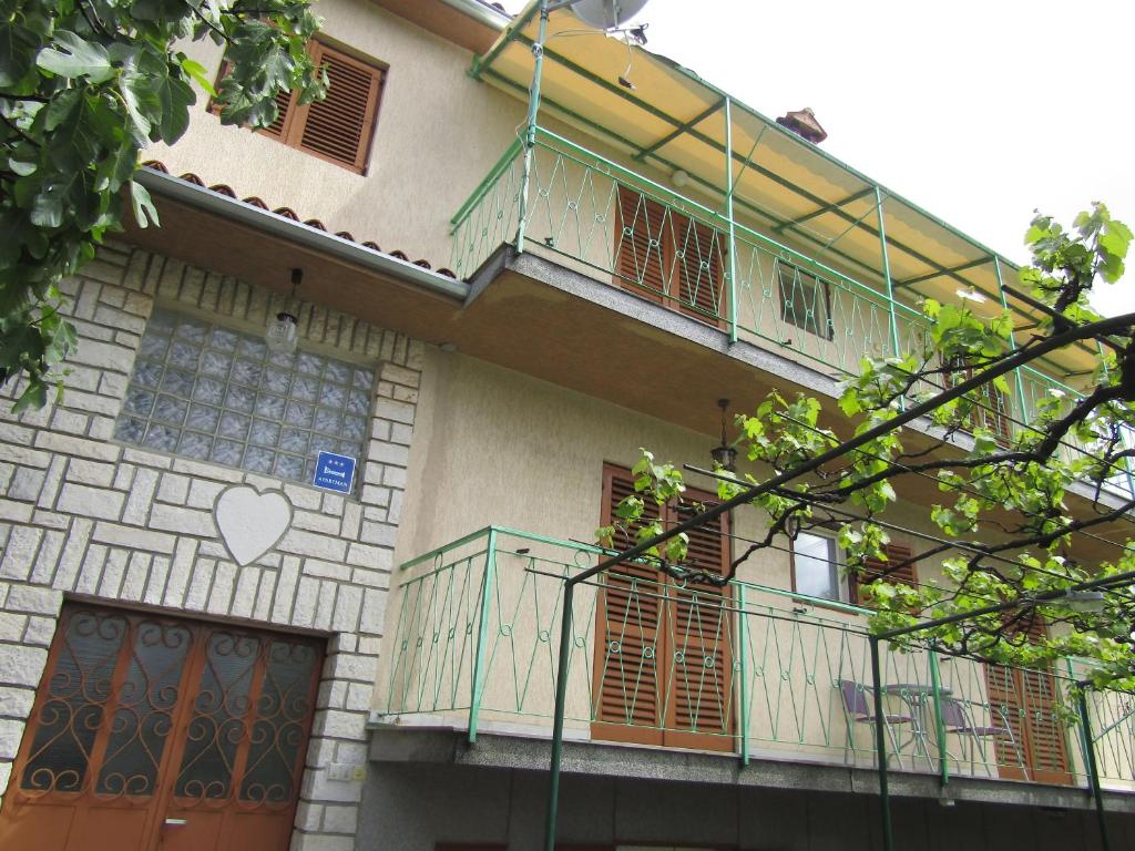 an apartment building with a balcony and a door at Green garden apartments in Rovinj
